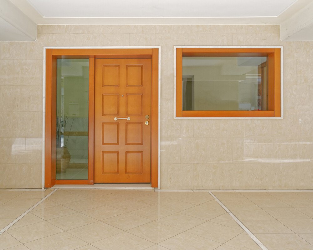 Porta d'ingresso e finestra con profili in legno in un ingresso
